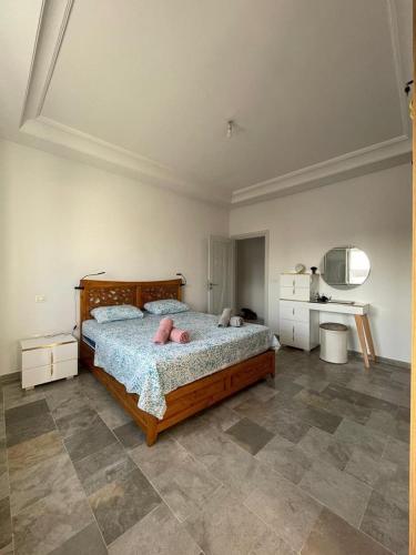 a bedroom with a large wooden bed with pink pillows at Corniche in Sousse