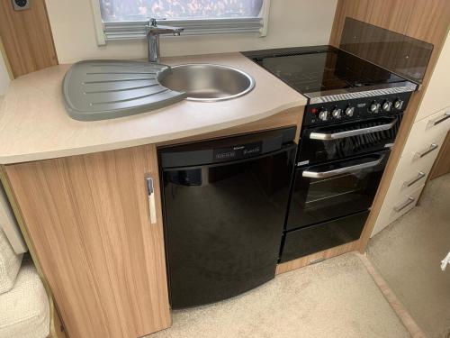 a kitchen with a sink and a stove at Country Roost in High Wycombe