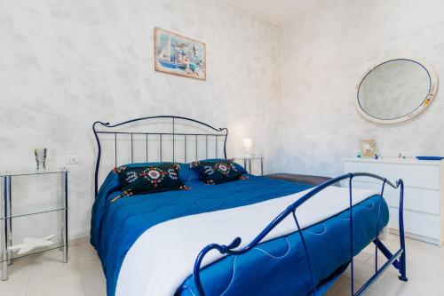 a bedroom with a blue and white bed and a mirror at Relax Ligure-5 min from the sea-Wifi-parking in Casarza Ligure