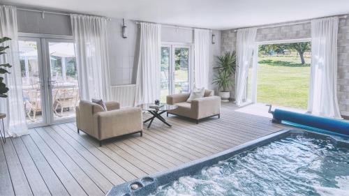 a living room with a swimming pool and chairs at York Cottage House & Spa in Bozeat