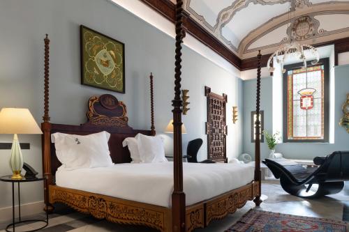 a bedroom with a canopy bed with white pillows at Hotel Boutique Casa del Limonero in Seville