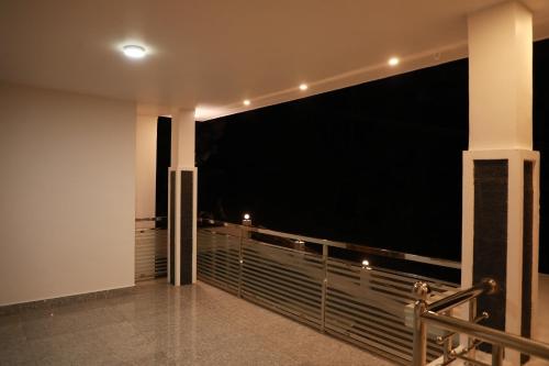 a balcony with a view of the night at Periyar Homes Plantation Stay in Thekkady