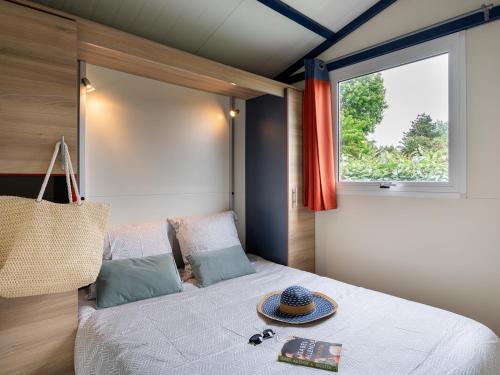 une chambre avec un lit avec un chapeau dessus dans l'établissement Domaine Les Jardins de Kergal, à Guidel-Plage