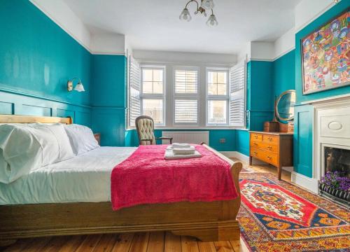 a blue bedroom with a bed and a fireplace at Margate Heritage House with Luxurious Beds, Garden, Pet Friendly , 3bd and 2 bath in Margate