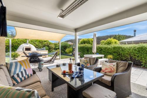 a patio with a table and chairs and a grill at Orford Coastal Retreat by Peppy Beach Retreats in Orford