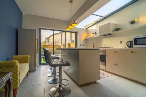 a kitchen with a counter and some chairs in a room at Margate Heritage House with Luxurious Beds, Garden, Pet Friendly , 3bd and 2 bath in Margate