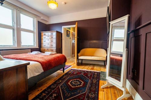 a bedroom with a bed and a dresser and a mirror at Margate Heritage House with Luxurious Beds, Garden, Pet Friendly , 3bd and 2 bath in Margate