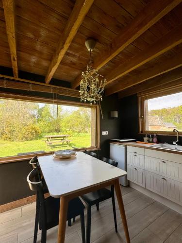 une cuisine avec une table et des chaises et une fenêtre dans l'établissement Domaine de la Ferme de Fourges, à Flancourt-Crescy-en-Roumois