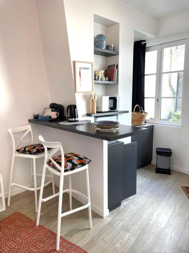 - une cuisine avec un comptoir, 2 chaises et une table dans l'établissement La Petite Jeannette Studio, à Rouen