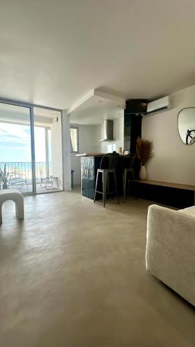 Il comprend un salon avec un canapé et une cuisine avec vue. dans l'établissement Studio face à la mer, à Canet