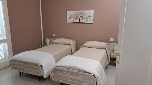 two beds in a hospital room with a picture on the wall at Villa Teresa in Oschiri