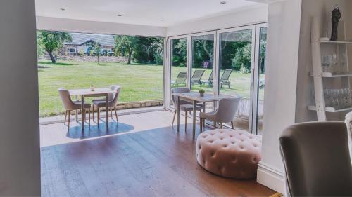 a dining room with a table and chairs and a window at York Cottage House & Spa in Bozeat