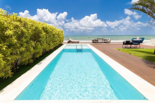 a swimming pool with a view of the ocean at Mansão Oceano, Luxo em Porto Mirim by Carpediem in Jacumã