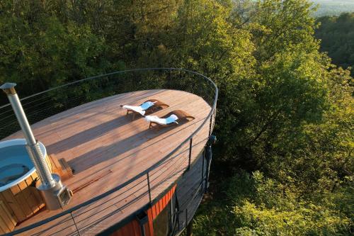 two people laying on the deck of a boat at Domaine des Étoiles - Logements Insolites in Gillonnay