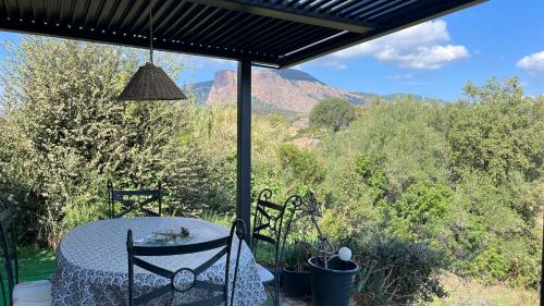 a table and chairs on a patio with a view of mountains at Le Gozzi in Afa