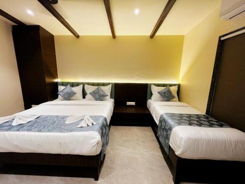 two beds in a room with yellow walls at Birds Nest Resort in Kinlivli