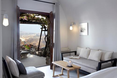 a living room with a couch and a table at Honeymoon Petra Villas in Imerovigli