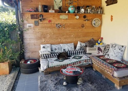 une chambre avec un canapé et des oreillers sur un patio dans l'établissement Chez Lolo, à Saint-Juéry