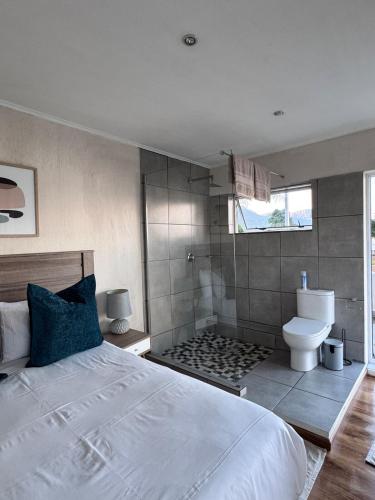 a bedroom with a white bed and a toilet at Olives by Agnes 33 in Hartbeespoort
