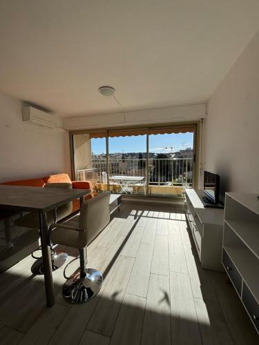 un salon avec une table et une grande fenêtre dans l'établissement Studio ideal pour les vacances, à Roquebrune-Cap-Martin