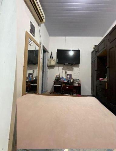 a living room with a flat screen tv and a large mattress at Casa em Parintins in Parintins