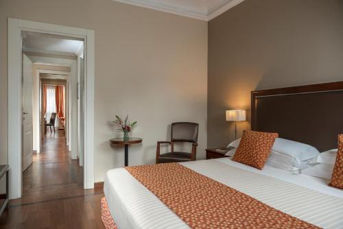 a hotel room with a large bed and a chair at Grand Hotel Adriatico in Florence