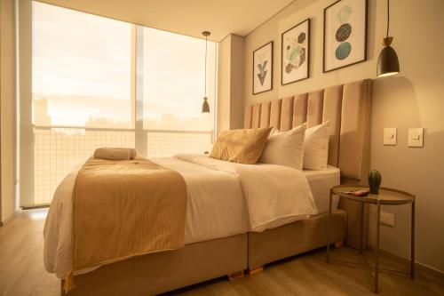 a bedroom with a large bed with a large window at Edificio QO 97 By Jalo in Bogotá