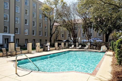 a swimming pool with chairs and a building at Hampton Inn Charleston-Historic District in Charleston
