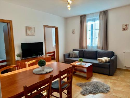 a living room with a table and a blue couch at Penzion U zámeckého parku in Třeboň