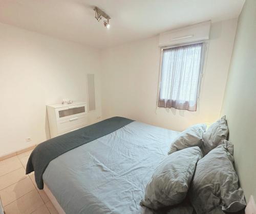 une chambre avec un grand lit avec des draps bleus dans l'établissement L'Escale Sétoise - Méditerranéenne, à Sète