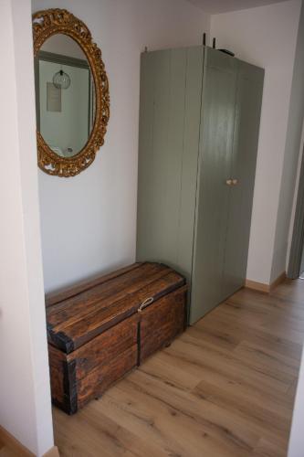 a mirror and a wooden bench in a room at Cà d'Nonu in Chiusa di Pesio