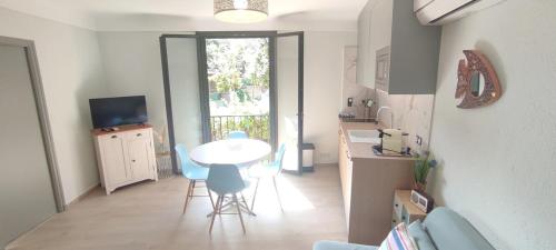 une cuisine avec une table et des chaises dans une pièce dans l'établissement Collioure au Faubourg T2 à 3min des plages, Clim, avec petit Parking, à Collioure