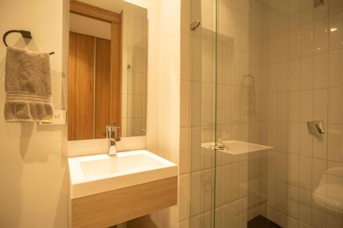 a bathroom with a sink and a glass shower at Edificio QO 97 By Jalo in Bogotá