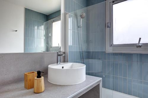 une salle de bain avec un lavabo et un miroir dans l'établissement Eiffel residence Gustave, à Paris