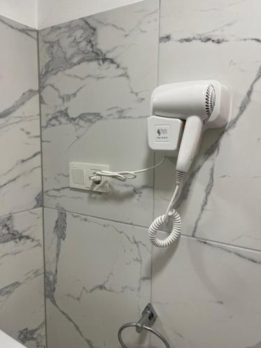 secador de pelo blanco en la pared del baño en Gabriela Studio Central, en Satu Mare