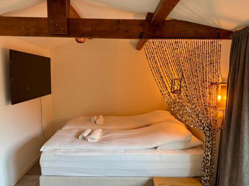 Cama en habitación con red en Wanderlust - Vlakbij strand - Omheinde privétuin, en Noordwijk aan Zee