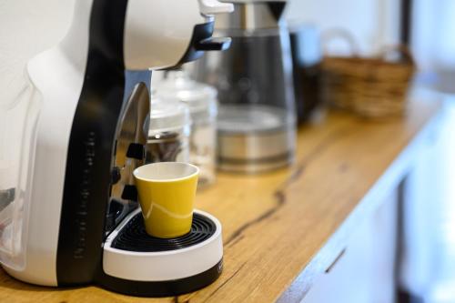 a coffee maker with a cup on a counter at Pescini's Home in Rosia