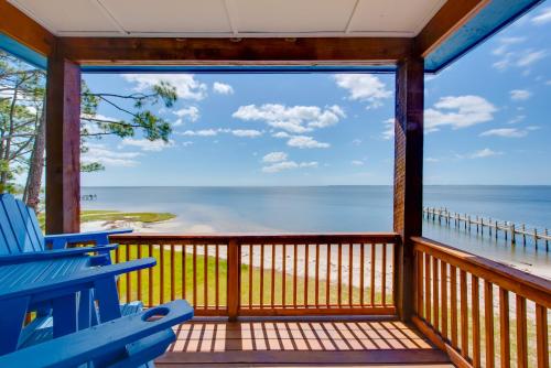 a screened in porch with a view of the ocean at Beachfront Retreat with Dock in Lanark Village! in Lanark Village