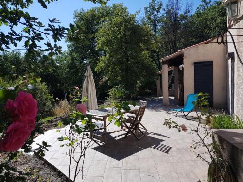 une terrasse avec une table, un parasol, une table et des chaises dans l'établissement Villa La Balle, à La Celle-sous-Gouzon
