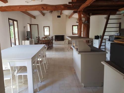 une cuisine avec un comptoir blanc et une table dans l'établissement Villa La Balle, à La Celle-sous-Gouzon