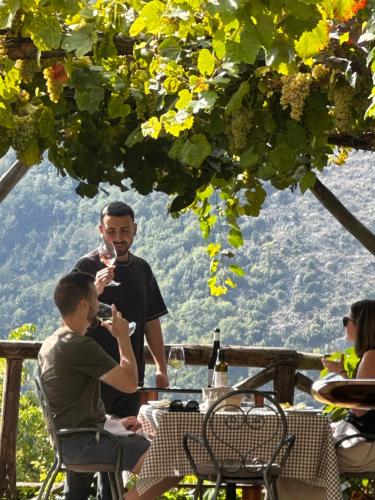 a man and a boy sitting at a table with a glass of wine at Reale Wine Resort in Tramonti