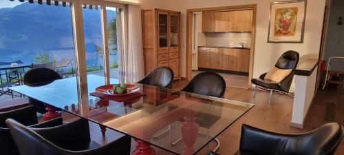 a dining room with a glass table and chairs at BellaRosa in Emmetten