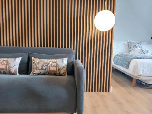 ein Wohnzimmer mit einer Couch und einem Bett in der Unterkunft Príncipe Boutique apartments in Vigo