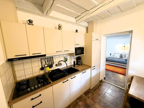 a kitchen with white cabinets and a sink at Harmony Vendégház Egerszalók in Egerszalók