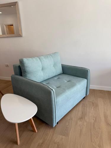 a blue couch and a stool in a living room at Radhime Luxury Apartments sleeps 5 in Orikum