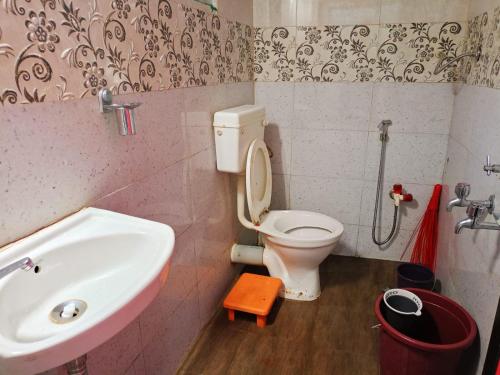 a small bathroom with a sink and a toilet at River Garden Guest House in Jambhulpāda