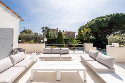 un patio blanc avec des canapés blancs sur un balcon dans l'établissement One of a kind 6 BR 6 bath villa sauna jacuzzi pool just 15 mns off town, à Cannes