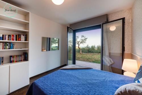 a bedroom with a blue bed and a book shelf at Anima Mediterranea in Albenga