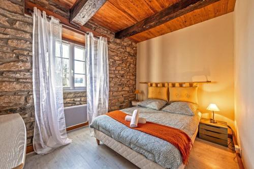 une chambre avec un lit et une grande fenêtre dans l'établissement Authentique maison de caractère à Ploumoguer, à Ploumoguer