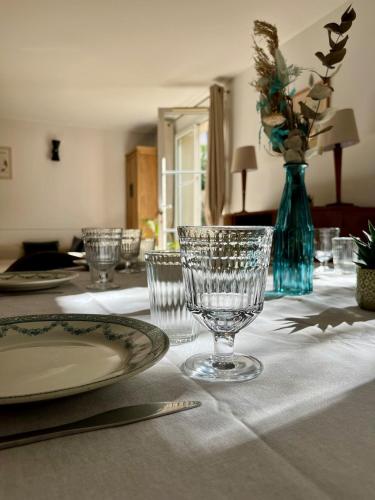 une table avec des verres et un vase bleu avec des fleurs dans l'établissement Paris-Montrouge, dans une allée privée, Métro, à Montrouge